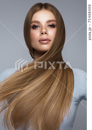 Beautiful blond girl with a perfectly smooth hair, and classic make-up. Beauty face and hair. 75498409