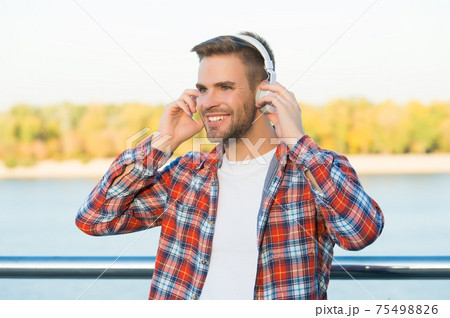 smiling bearded man listen music in digital earphones smiling bearded man listen music in digital earphones 75498826