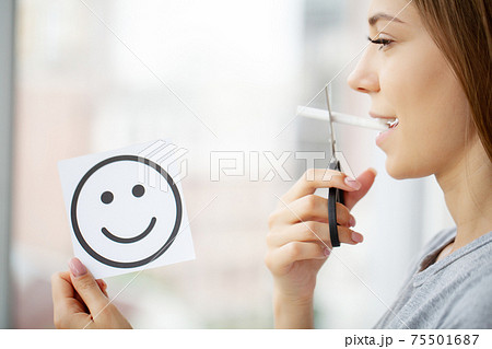 Stop smoking, woman cuts a cigarette with scissors Stop smoking, woman cuts a cigarette with scissors 75501687