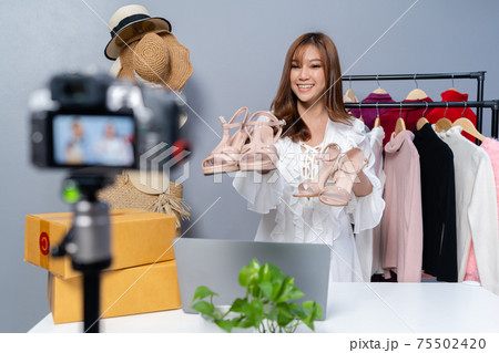 woman selling shoes and clothes online by camera live streaming, business online e-commerce at home woman selling shoes and clothes online by camera live streaming, business online e-commerce at home 75502420