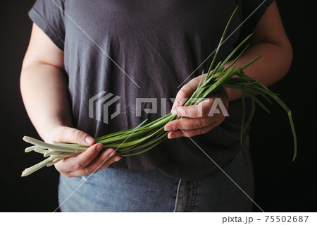 Vegetarian woman holding fresh greenery in hands 75502687