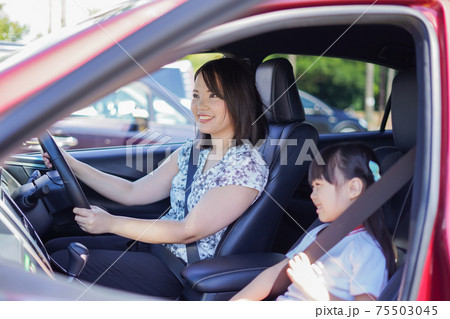 お母さんと車に乗る小さな女の子 75503045