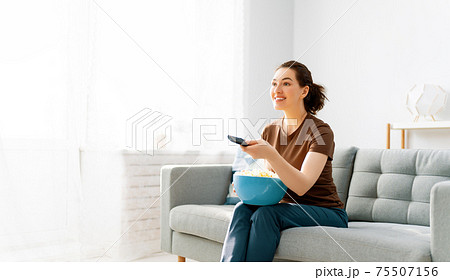 Young woman watching TV Young woman watching TV 75507156