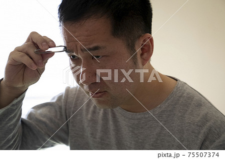 まゆ毛を整える中年男性 75507374