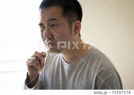 あごヒゲを抜く中年男性 75507378