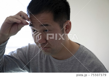 まゆ毛を整える中年男性 まゆ毛を整える中年男性 75507379