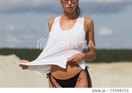Beautiful female in tank top on beach 75509153