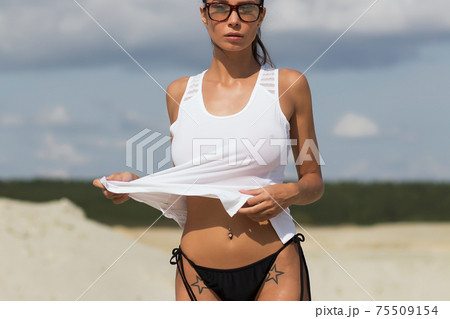 Beautiful female in tank top on beach 75509154