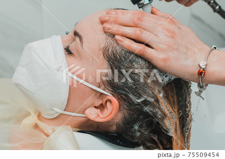 Woman in a barbershop dyes her hair, washing her head in the process of dyeing her hair. Woman in a barbershop dyes her hair, washing her head in the process of dyeing her hair. 75509454
