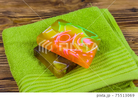 Set of handmade soap bars and towel on wooden background 75513069
