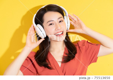 Woman wearing wireless headphones Woman wearing wireless headphones 75513650