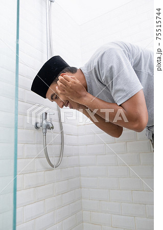Young Muslim man perform ablution wudhu before prayer at home 75515744