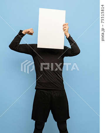 Young man in black attire with blank sheet of paper isolated on blue background. Young man in black attire with blank sheet of paper isolated on blue background. 75515814