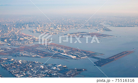 早朝の東京湾上空から羽田空港を一望 75516316