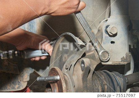 Car Mechanic or Auto Mechanic Loosen Shock Absorber Bolt by Wrench Car Mechanic or Auto Mechanic Loosen Shock Absorber Bolt by Wrench 75517097