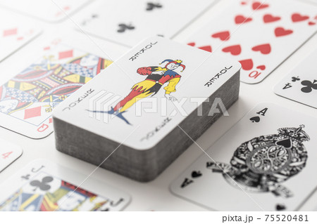 Joker on the pile of cards surrounded by various other playing cars 75520481