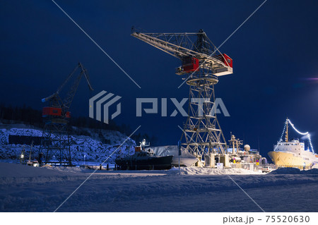 Industrial cranes and cargo ships are in port of Turku 75520630