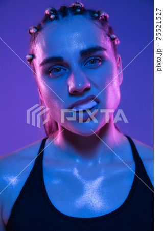 Close-up portrait of athletic girl MMA fighter isolated on blue background Close-up portrait of athletic girl MMA fighter isolated on blue background 75521527