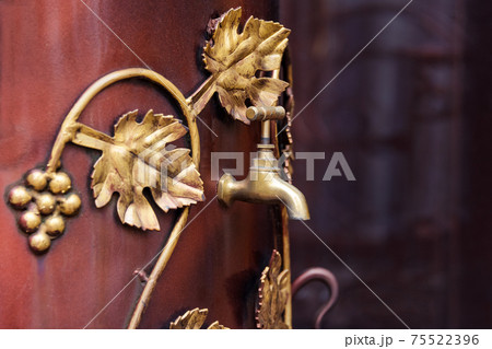 Metal barrel with a tap for wine. Retro style barrel for storing and aging of alcohol spirits beverages and wine, street fair equipment. Metal barrel with a tap for wine. Retro style barrel for storing and aging of alcohol spirits beverages and wine, street fair equipment. 75522396