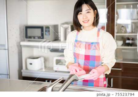 キッチンで皿を洗う若い女性 キッチンで皿を洗う若い女性 75523794