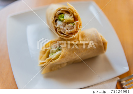 Chicken breast with caesar dressing and lettuce in a gluten-free tortilla wrap Chicken breast with caesar dressing and lettuce in a gluten-free tortilla wrap 75524991