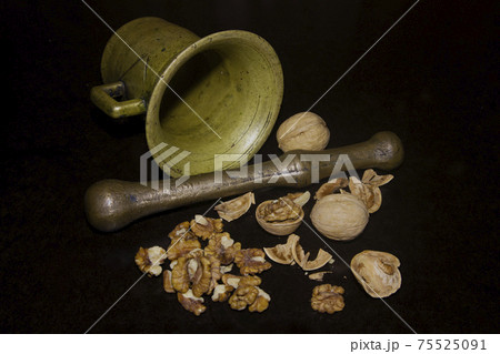 Ancient mortar and cracked walnuts with shells Ancient mortar and cracked walnuts with shells 75525091