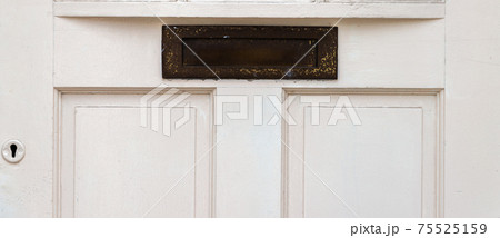 Old letterbox in the door, traditional way of delivering letters to the house, old mailbox 75525159