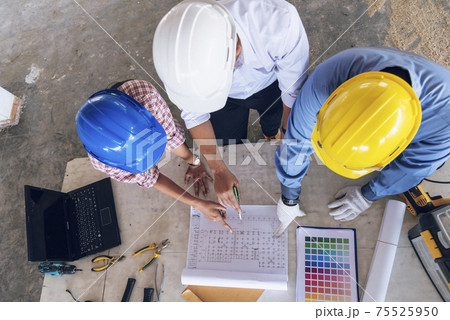 Construction engineer teamwork Safety Suit Trust Team Holding White Yellow Safety hard hat Security Equipment on Construction Site. Hardhat Protect Head for Civil Construction Engineer Concept 75525950