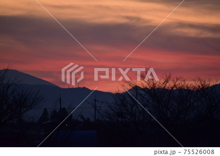 赤く染まった夕暮れ時の空とシルエットたち 75526008