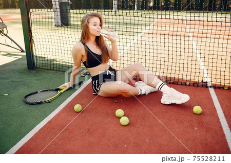 Beautiful and stylish girl on the tennis court 75528211