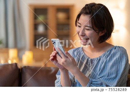 夜スマホでテレビ電話をする若い女性 75528289