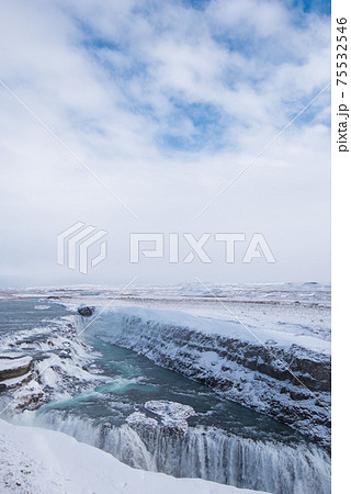 北欧アイスランドの冬期ゴールデンサークルのグトルフォスの滝と青空の写真素材