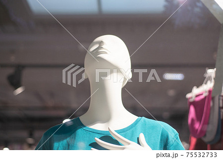 mannequins on a shop window in a blue t-shirt looks up 75532733