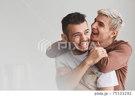 Portrait of Carefree Gay Couple Indoors 75533292