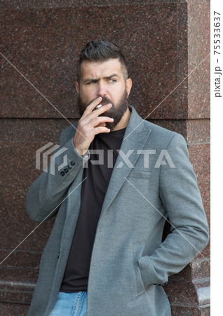 brutal mature bearded man with moustache smoking cigarette  75533637