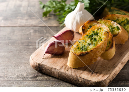 Garlic bread slice on wooden table.  75535030