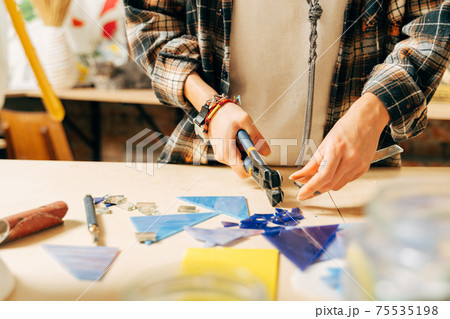 Woman putting out a mosaic of glass with tweezers, fusing, craftsmanship Woman putting out a mosaic of glass with tweezers, fusing, craftsmanship 75535198