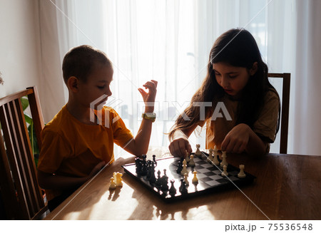 Kids having great time together playing chess Kids having great time together playing chess 75536548