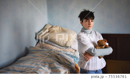 Poor sad small girl standing and looking at camera indoors at home, poverty concept. 75536761