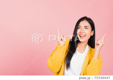 woman standing makes gesture two fingers point upwards above presenting product something woman standing makes gesture two fingers point upwards above presenting product something 75540447