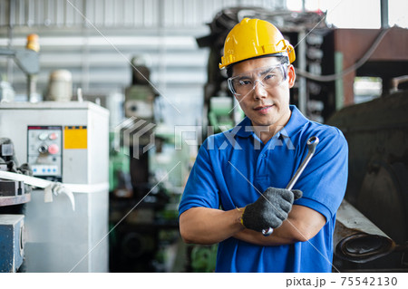 portrait image asian engineer men wearing uniform safety and holding wrench tool in factory. portrait image asian engineer men wearing uniform safety and holding wrench tool in factory. 75542130