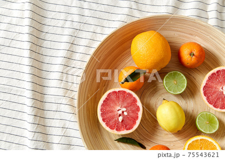 close up of citrus fruits on wooden plate close up of citrus fruits on wooden plate 75543621