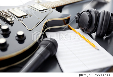 close up of guitar, music book and headphones 75543733