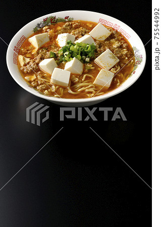 万能ねぎが沢山のっている山椒入りの麻婆豆腐ラーメンを黒背景で撮影 75544992