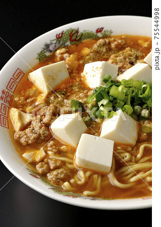 万能ねぎが沢山のっている山椒入りの麻婆豆腐ラーメンを黒背景で撮影 75544998