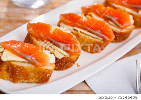 Slices of fresh baguette with butter and salmon 75546408