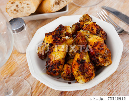 Tasty crispy grilled chicken wings on plate 75546916