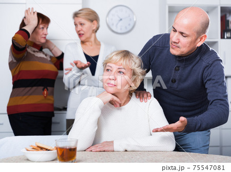 Mature female is sitting upset and man is apologizing 75547081