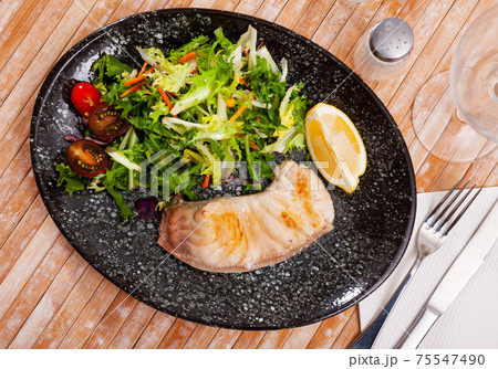 Fried porbeagle steak with vegetable salad and lemon wedge 75547490