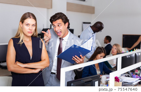 Irritated boss scolding young female subordinate 75547640